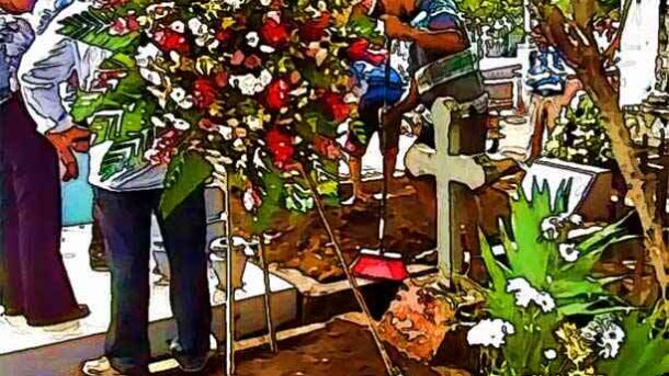 Personas dejando flores en una tumba en el cementerio, símbolo de respeto y recuerdo hacia los difuntos.