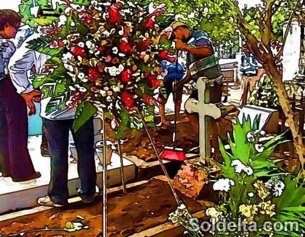 Personas dejando flores en una tumba en el cementerio, símbolo de respeto y recuerdo hacia los difuntos.