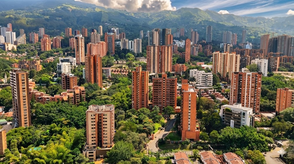 Panoramic view of Medellín, Colombia showing modern high-rise buildings, green hills, and urban neighbourhoods in the Aburrá Valley
